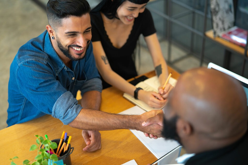 A small business owner shaking hands with a lender employee.